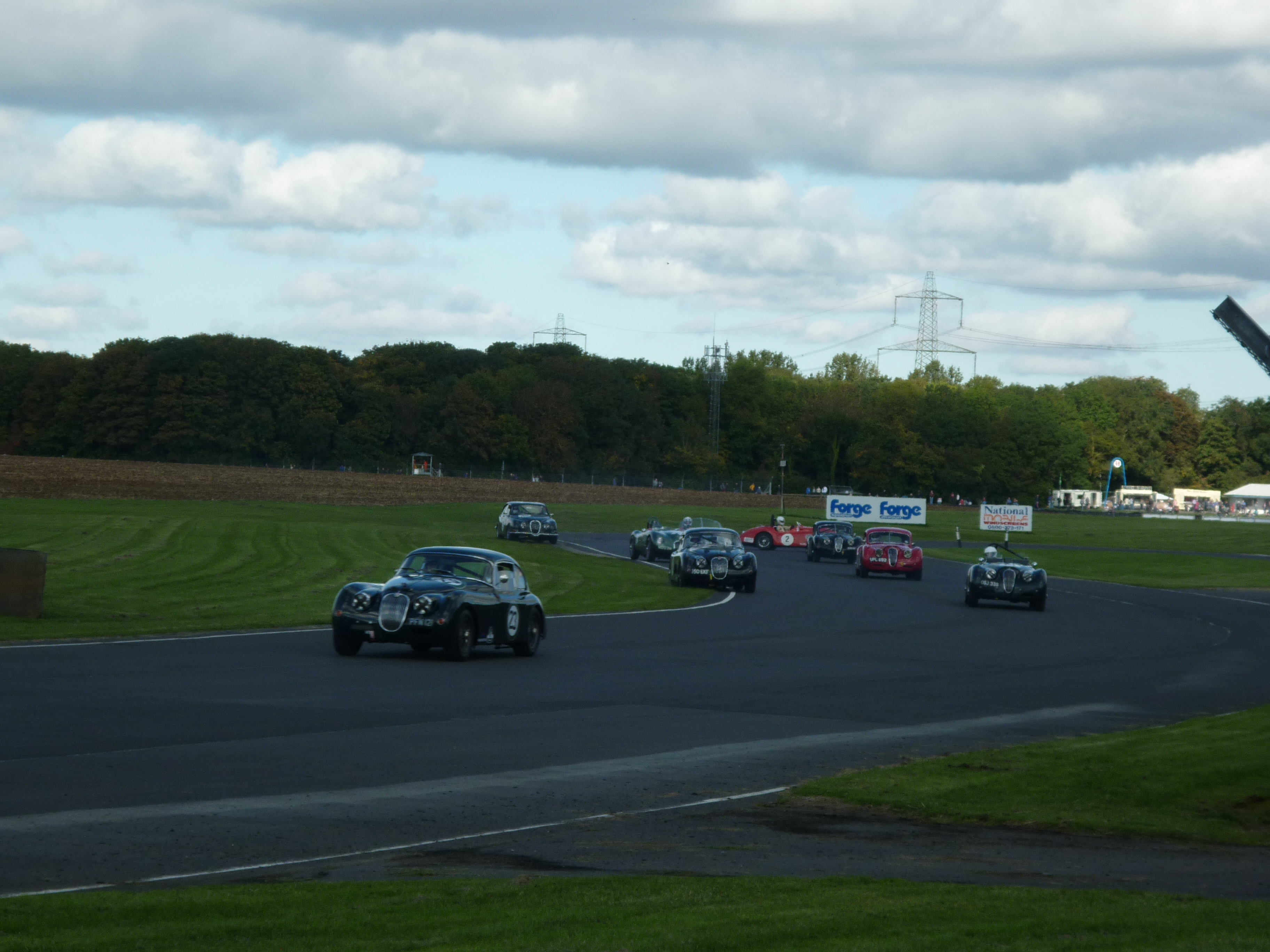 Car spins centre pack on the opening lap of the pre-66 Jaguar race
